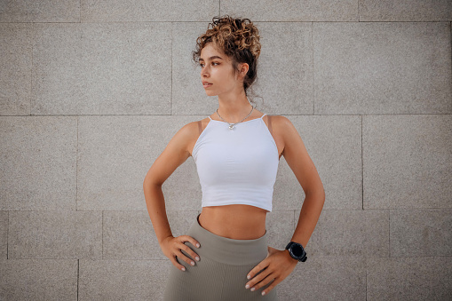Young woman using smart watch for the running in the city