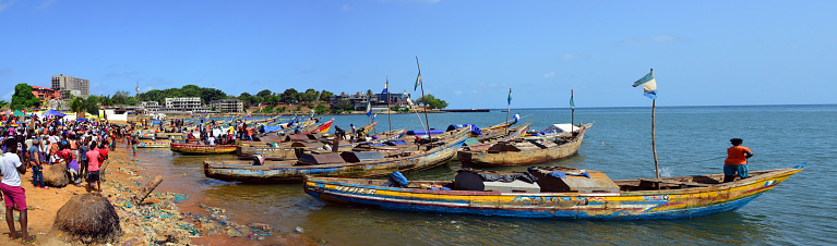 Freetown, Western Area, Sierra Leone: busy artisanal fishing harbour at Man of War Bay, Aberdeen Peninsula - crowds of buyers wait on the beach for the fresh fish being landed.
