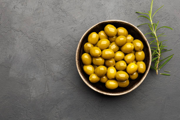 istock Green olives in a bowl on black (dark) slate background. 1333229105