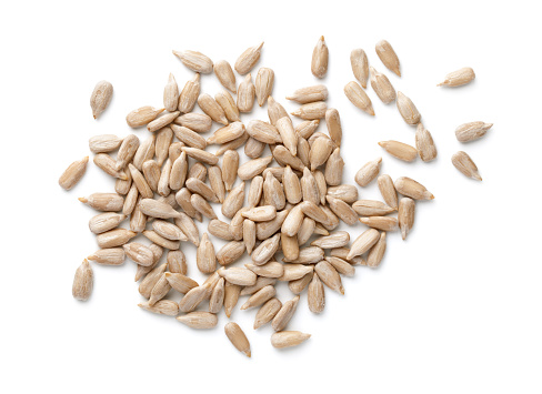 Peeled sunflower seeds isolated on white background. Top view, flat lay