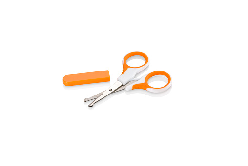 Orange and white nail scissors with safety cap off, isolated