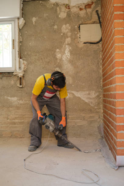 istock Young builder breaking up a house floor with a jackhammer. 1333236337