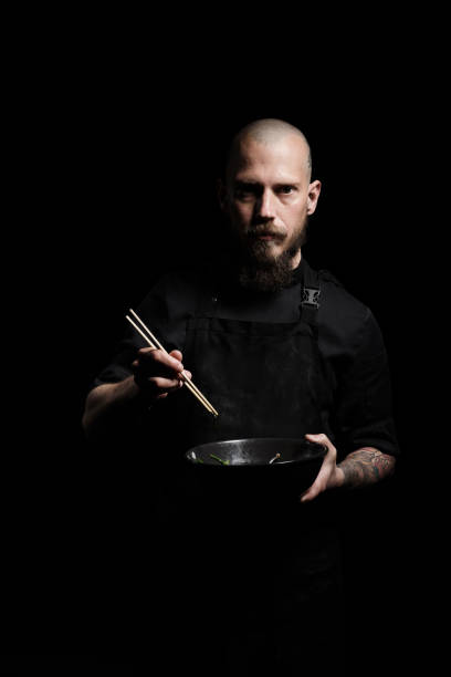 Chef with bowl and chopsticks on black stock photo