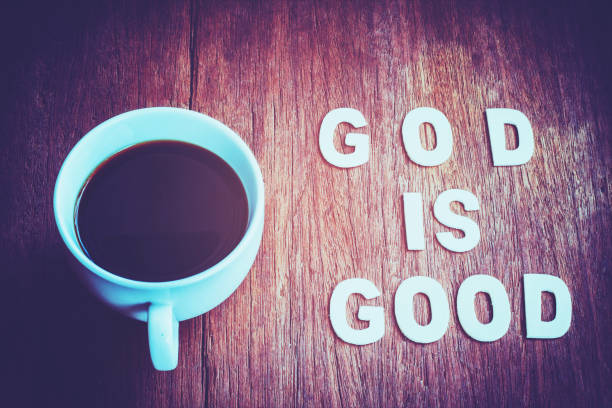 Word 'God is good' with a cup of coffee on wooden table, christian concept background stock photo