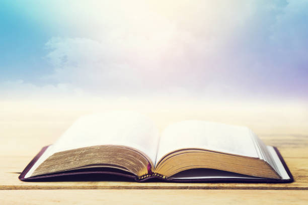 istock open bible on wooden table over cloudy blue sky background 1333237435
