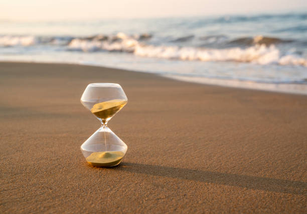 istock Flowing hourglass on the beach at sunrise 1333243429