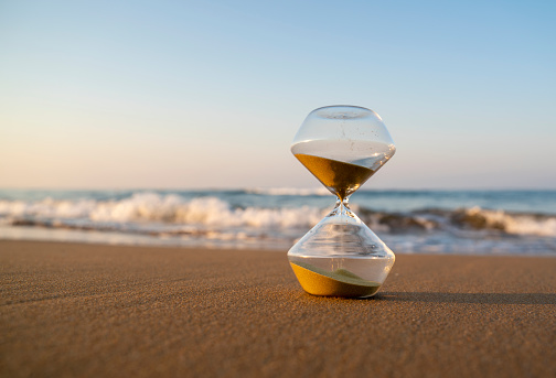 Flowing hourglass on the beach at sunrise
