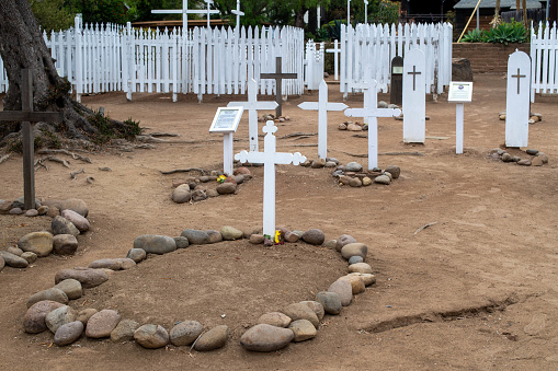 A close up on a set of Catholic crosses and relics made out of wood, stone, pine cones, and planks scattered all over a lush forest and a vast groove spotted during a hike on a Polish countryside