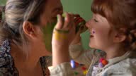 istock Mother and daughter playing painting each others face at home 1333244654