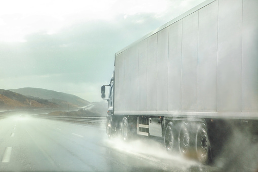 Truck in motion on highway in stormy weather