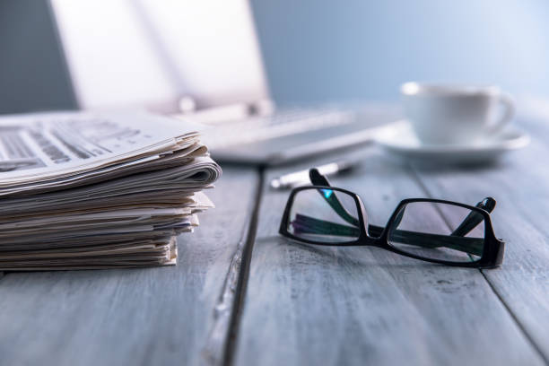 istock Newspapers with glasses and laptop. 1333246364