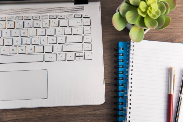 istock laptop with pens on notepads on table 1333246369