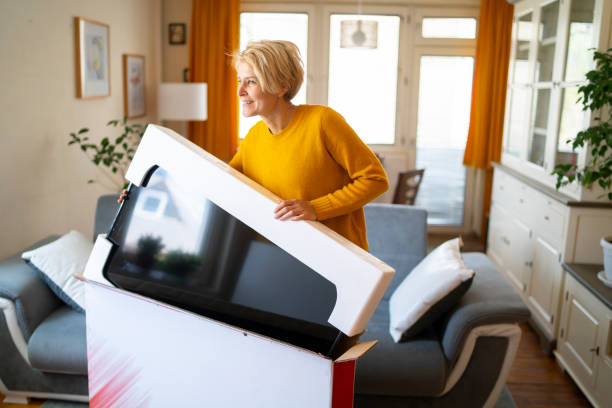 istock A young woman lifting her new tv from its protective box 1333247512