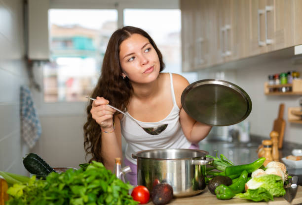 istock Young confused woman decides what to cook in kitchen 1333249689
