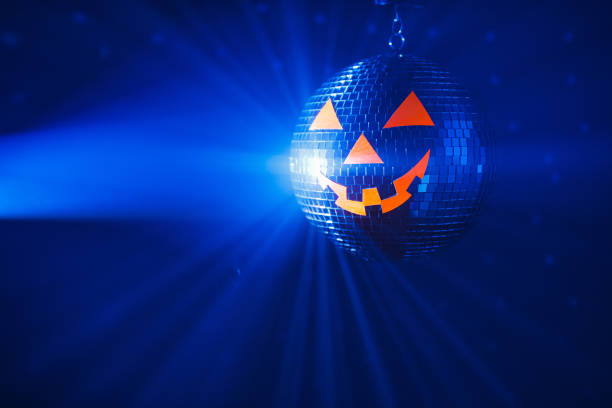 istock Halloween party pumpkin disco ball, blue shiny rays background 1333250620
