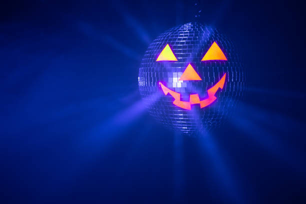 istock Halloween party pumpkin disco ball, jack o'lantern with shiny rays in smoke 1333250637
