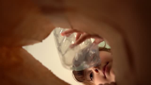 Girl putting recycling material into a bag - bag point of view