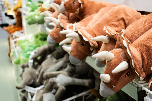 Close-up of toy dinosaurs on store shelves. Blurry soft toys on background. Toy shop Close-up of toy dinosaurs on store shelves. Blurry soft toys on background. Toy shop. toy store stock pictures, royalty-free photos & images