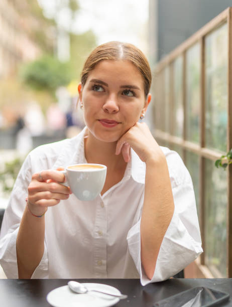 istock Young attractive girl drinking coffee in cafe 1333254859