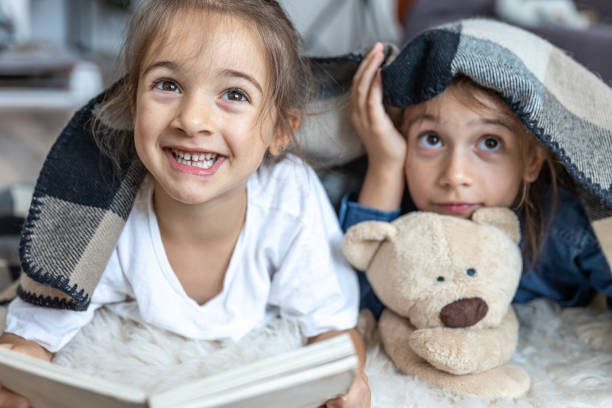 istock Children have fun reading a book together. 1333258181