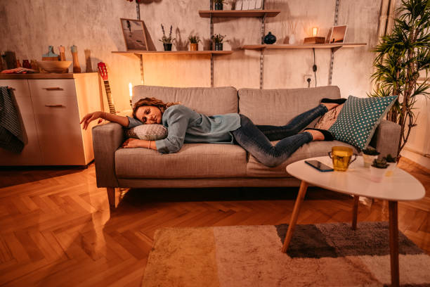 istock Tired young woman sleeping on couch at home 1333258829