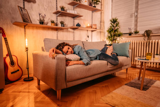 istock Tired young woman sleeping on couch at home 1333258860