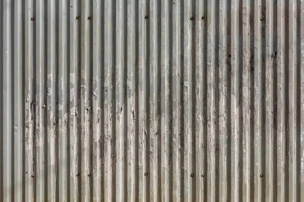 corrugated zinc-plated sheet fence with paper advertisements leftovers - full frame background and texture