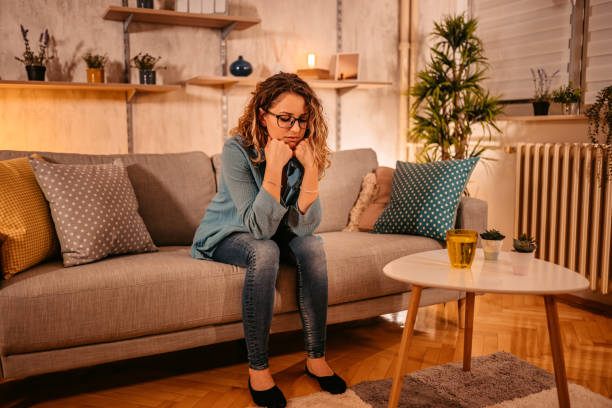 istock Woman sitting alone at home looking sad and distraught 1333259441