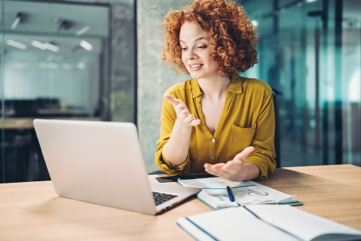 Smiling young businesswoman with a laptop in a video call