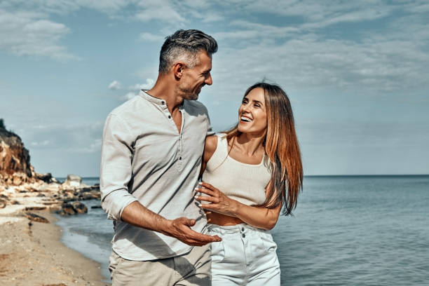 istock A loving couple walking down seaside avenue looking at each other. 1333263337