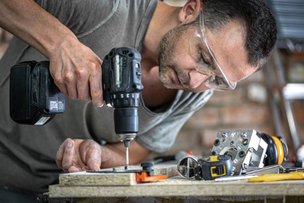 un carpintero profesional utiliza tornillos de madera, tornillos. - hand drill fotografías e imágenes de stock