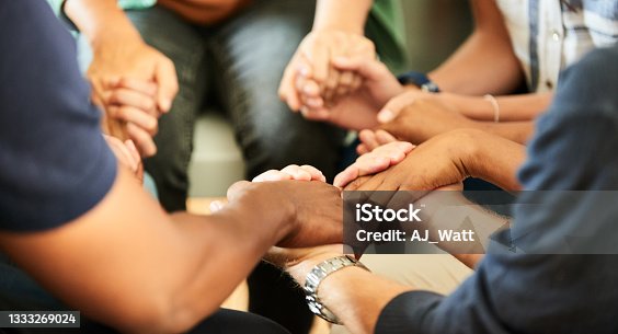 istock People holding hands together during a support group meeting 1333269024