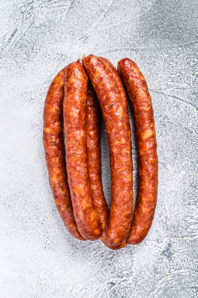 istock Hot Smoked sausages on a rustic table. White background. Top view 1333276586