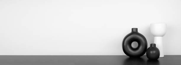 Modern black and white home decor on a black shelf banner