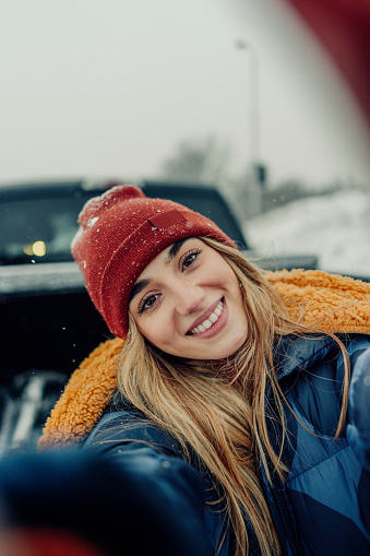 Self-portrait photo of a young woman on her solo winter road trip.