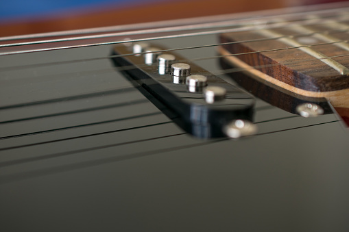 Close-up detail of the pickup of an electric guitar. They are transducers that capture the vibration of the strings. Music and electronic mixed.