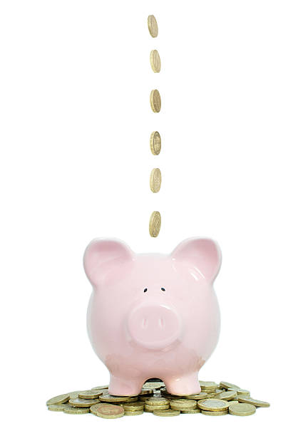 Piggybank Coins falling into a piggy bank piggy bank gold british currency pound symbol stock pictures, royalty-free photos & images