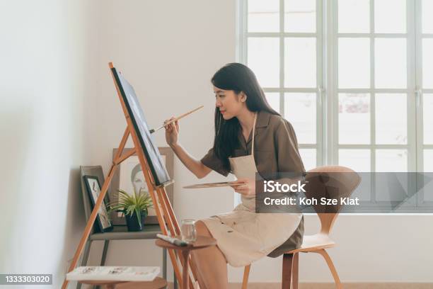 Female Asian Painter Creating Art In Her Home Studio Stock Photo - Download Image Now