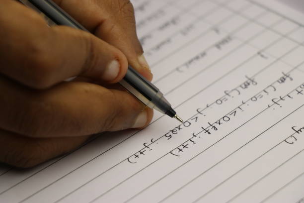 istock Hand of student writing computer programs on paper with black pen 1333313205