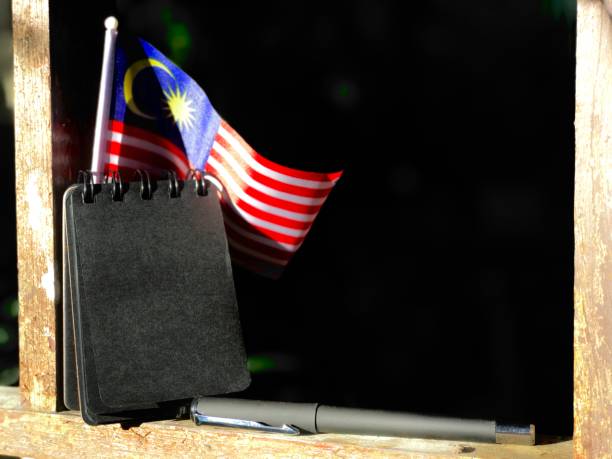 Flag with a blank black note and pen on a dark background