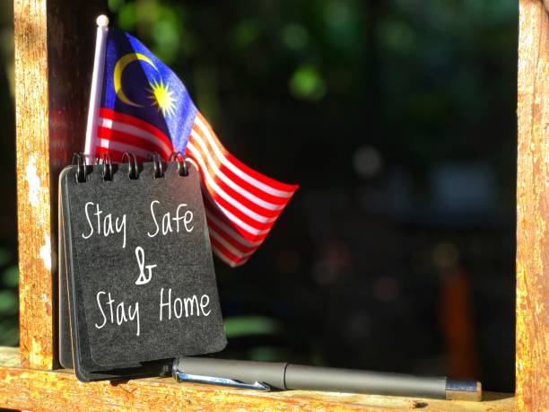 istock Flag with black spiral note written Stay Safe and Stay Home on dark background 1333314473