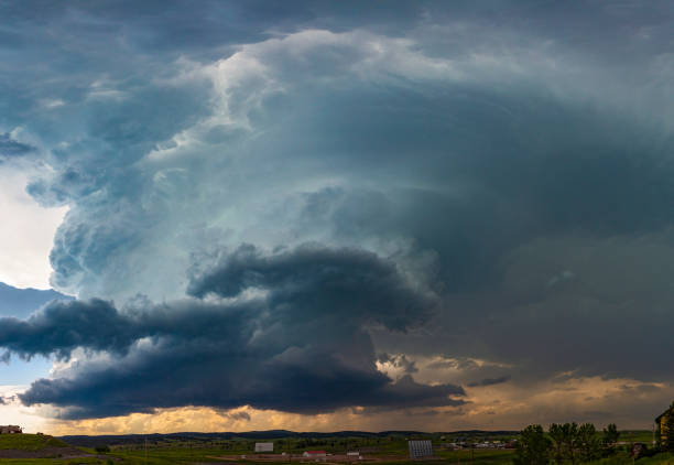 Rotating developing supercell storm cloud forms over rural drive-in cinema in South Dakota: cumulonimbus cloud,