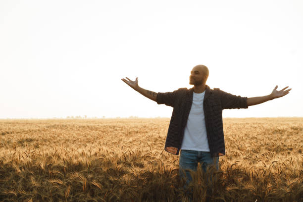 istock Young man standing in wheat field on sunset 1333322082