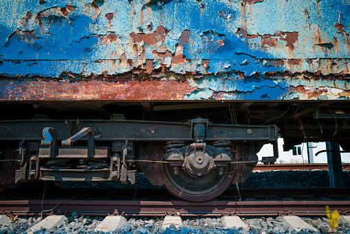 Color image depicting an old train carriage that has been abandoned on the railroad track and left to rust and ruin.