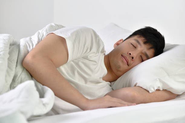 istock Handsome Young Asian man sleeping in bed 1333323184