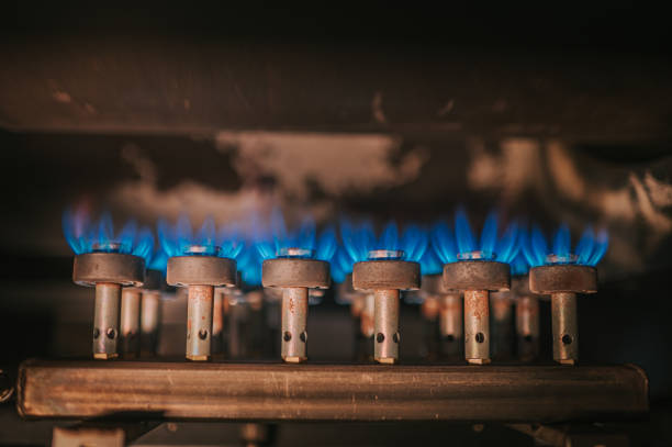 feu sur cuisinière à gaz avec fond sombre - flame natural gas boiler burner photos et images de collection