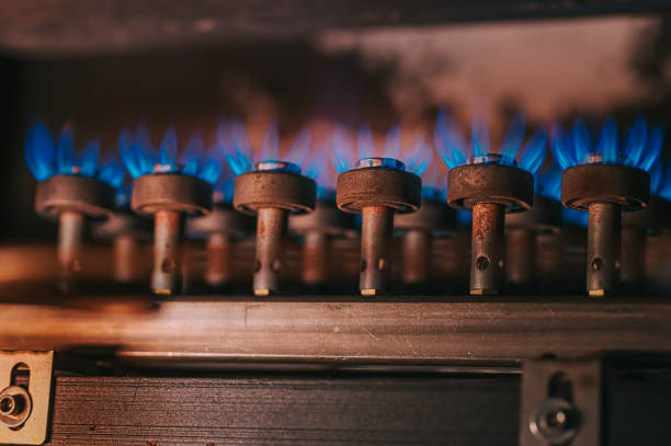 feu sur cuisinière à gaz avec fond sombre - flame natural gas boiler burner photos et images de collection