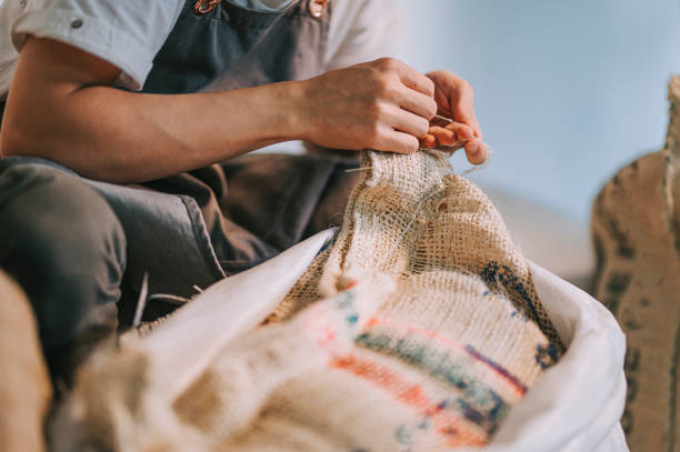 pracownik magazynu z bliska odłączający surowy worek z ziarnem kawy - coffee sack bag warehouse zdjęcia i obrazy z banku zdjęć