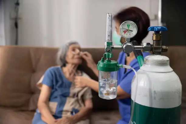 Photo of Elderly woman wearing oxygen nasal canula at home.