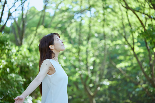 Young Japanese woman relaxing in the woods